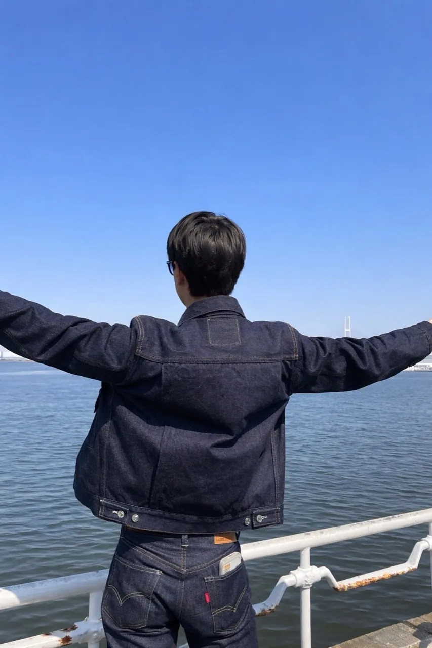 デニムスタイルで海を眺める後ろ姿